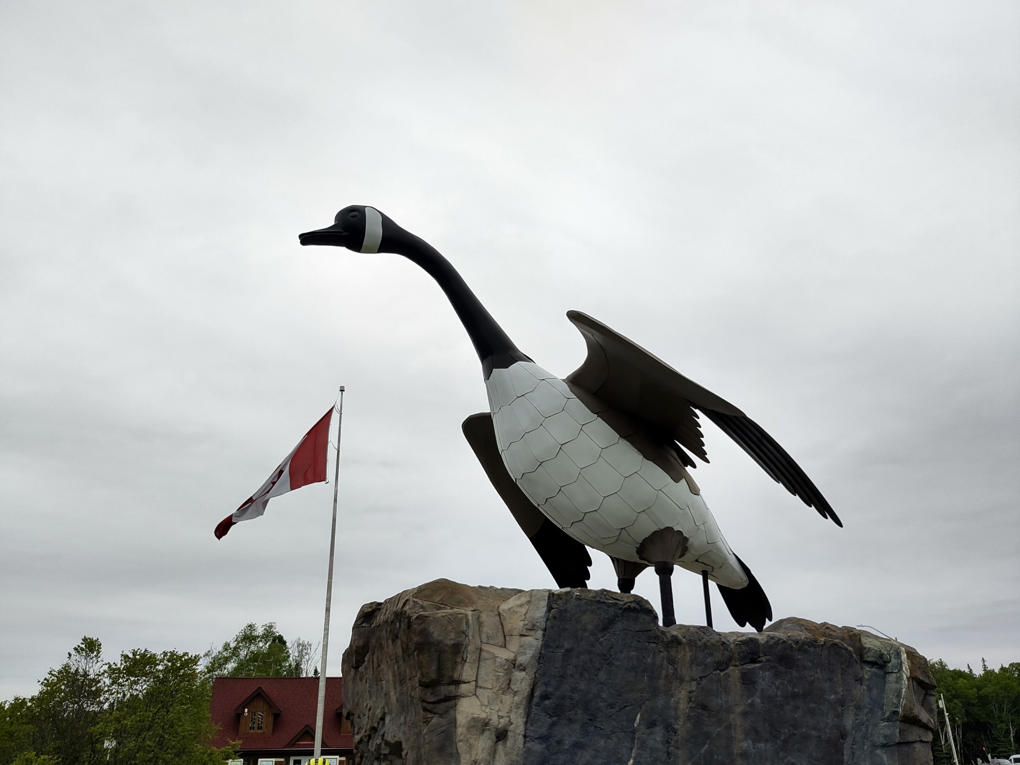 A giant statue of a goose, with a Canadian flag to its left.